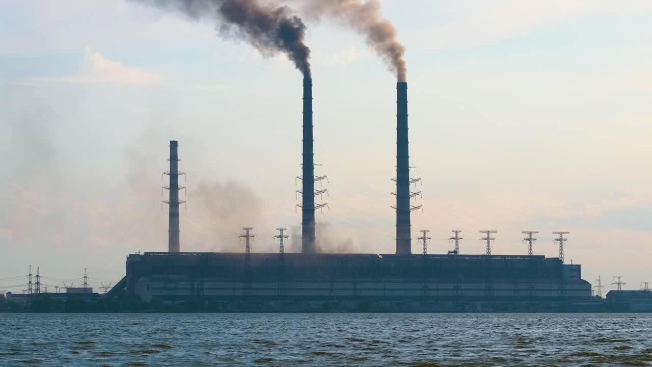 燃煤电厂的高管道，黑烟向上移动，污染大气。用化石燃料生产电能的概念视频素材