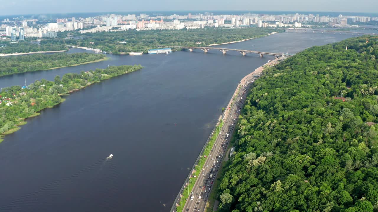 乌克兰首都基辅上空美丽的飞行。公园和树冠在绿叶。许多房屋、桥梁和第聂伯河。视频素材