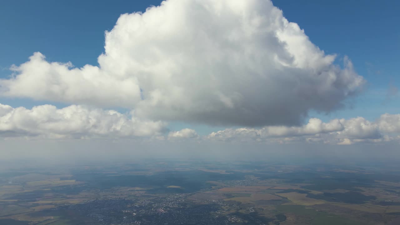 高空从飞机窗口俯瞰覆盖着白色蓬松积云的地面视频素材