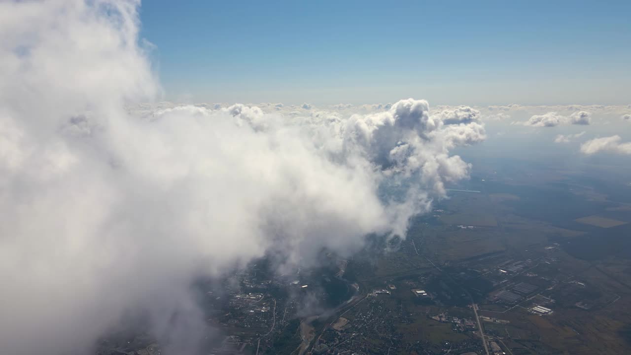 高空从飞机窗口俯瞰覆盖着白色蓬松积云的地面视频素材