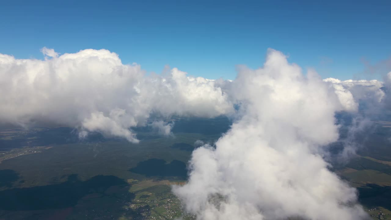 高空从飞机窗口俯瞰覆盖着白色蓬松积云的地面视频素材