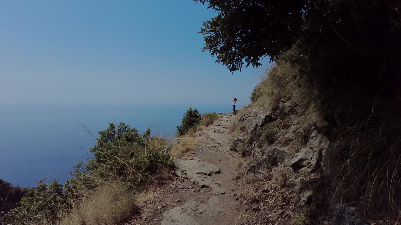 一个女人走在海边的山上视频素材