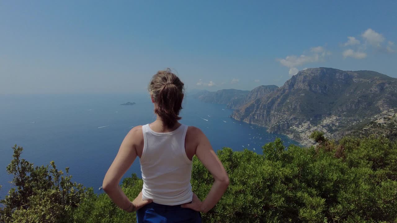 一个女人走在海边的山上视频素材