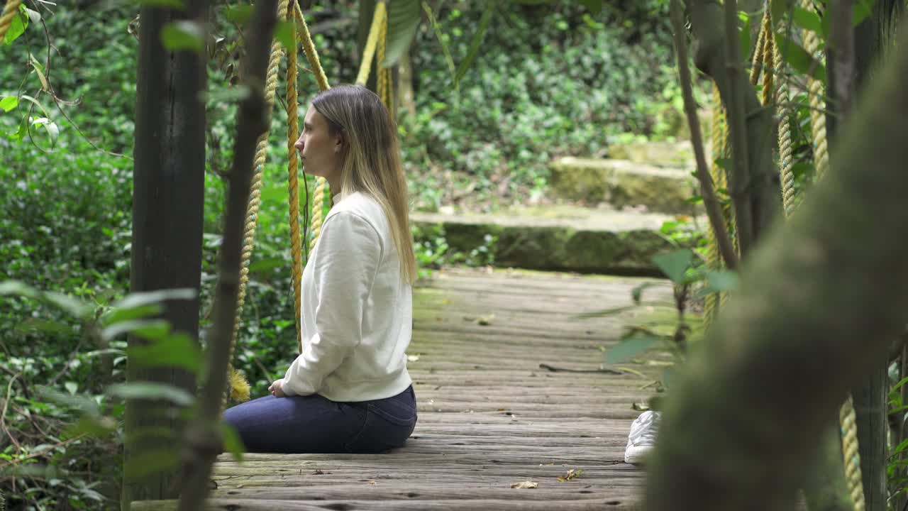 在她放松的时候，一个女人在森林里安静地冥想和平静视频素材