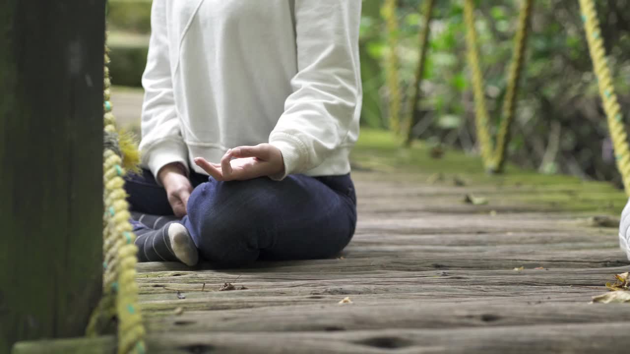 在她放松的时候，一个女人在森林里安静地冥想和平静视频素材