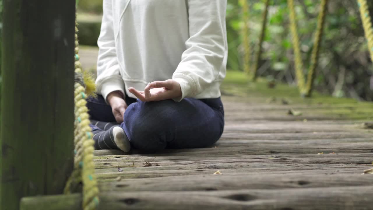 在她放松的时候，一个女人在森林里安静地冥想和平静视频素材