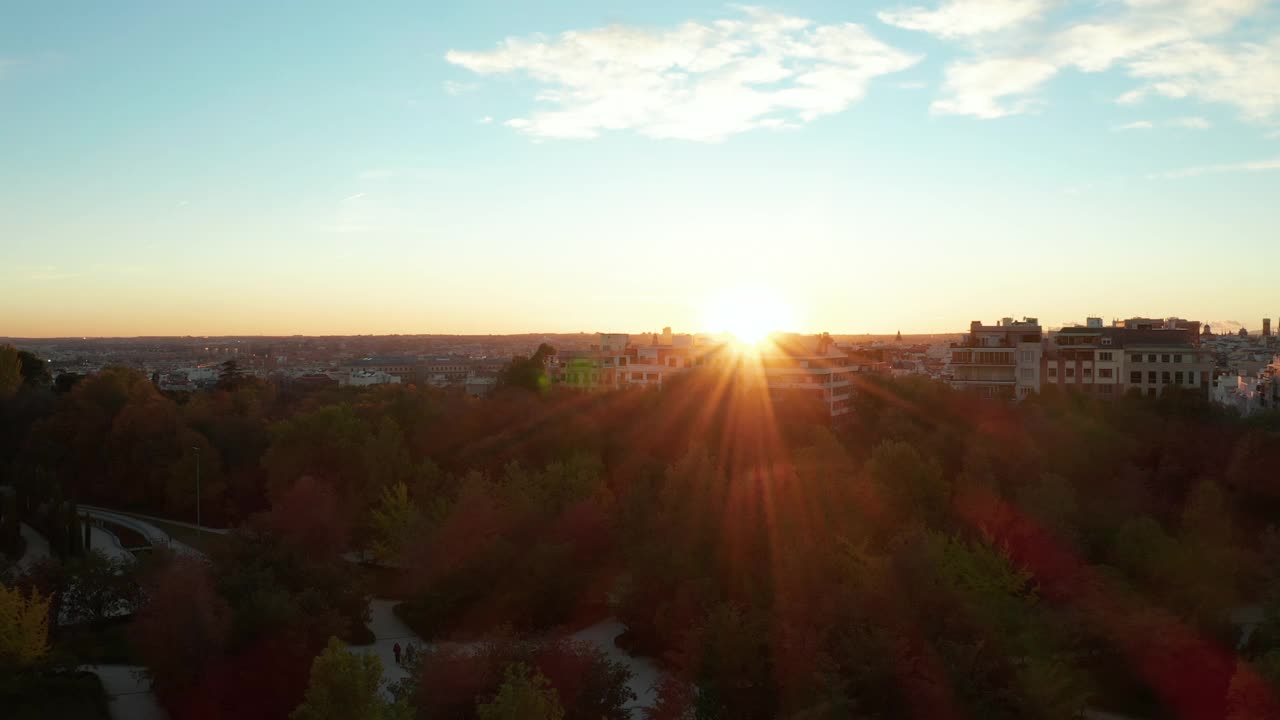 躲在公园的公寓楼后面，在明亮的夕阳下飞翔。晚上浪漫的观点视频素材