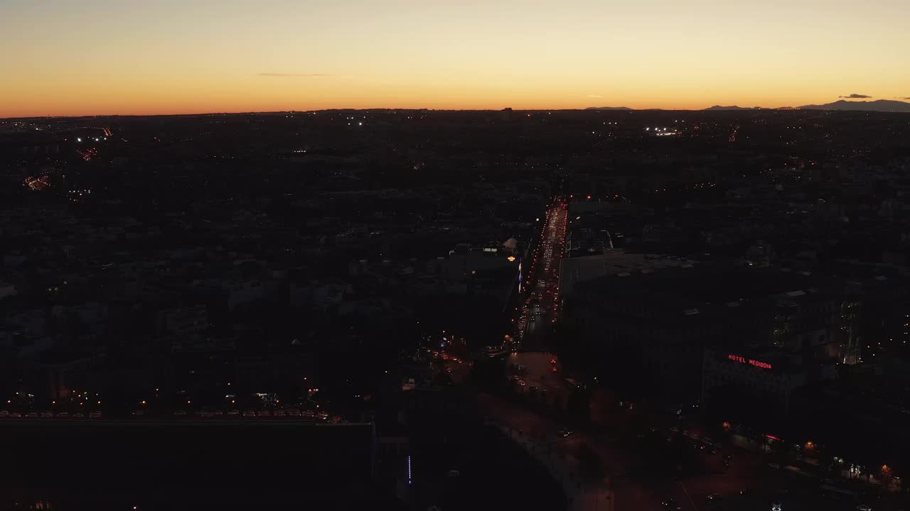 城市街道交通的空中全景镜头。黑暗的场景与明亮的日落天空形成对比视频素材