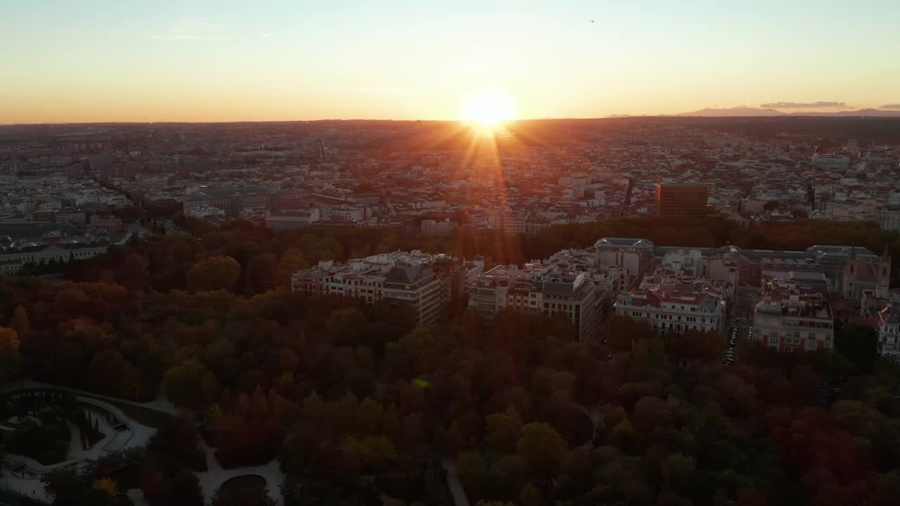 在大城市公园上空降落飞行。夕阳下的浪漫风景。城市在日落时分视频素材