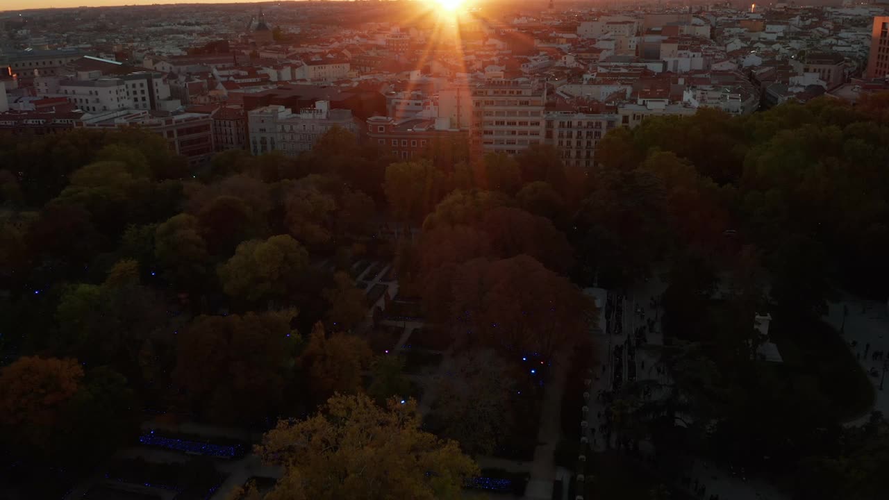 公园附近的公寓大楼向后展示。夕阳下的城市全景视频素材