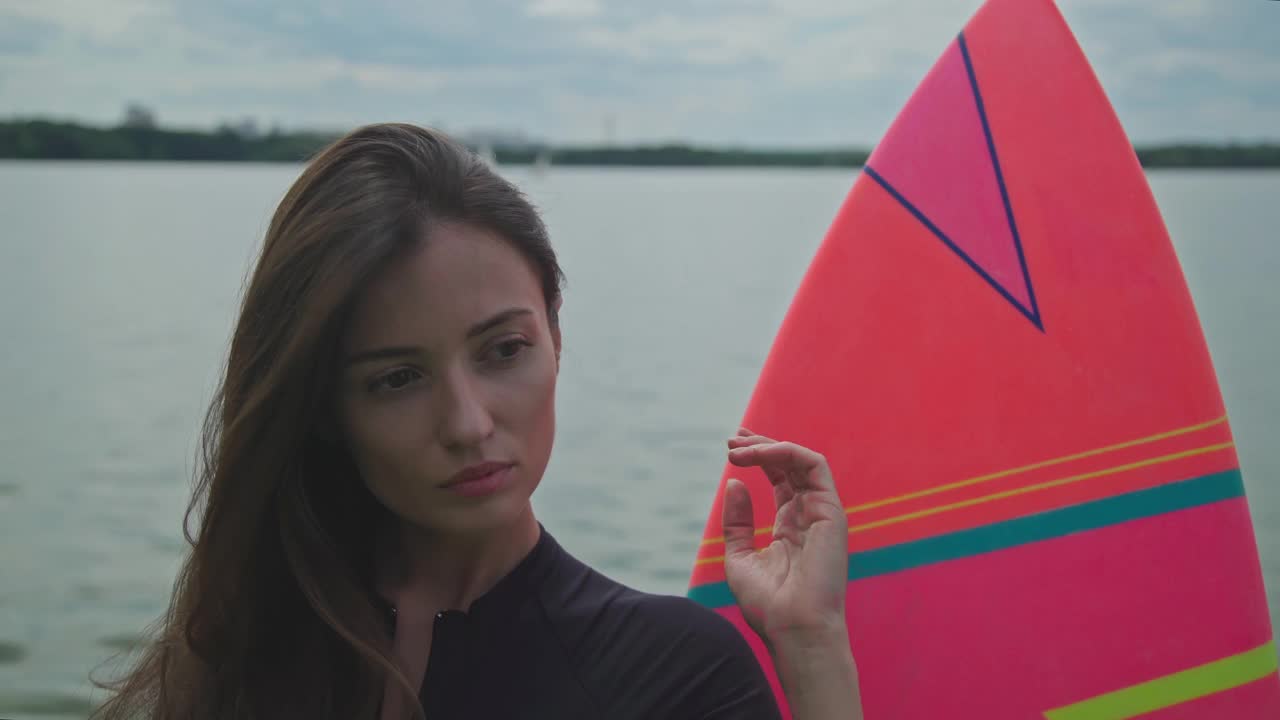 冲浪女孩风格。近距离观察快乐的女孩在泳装站与冲浪板在海滩上。视频素材