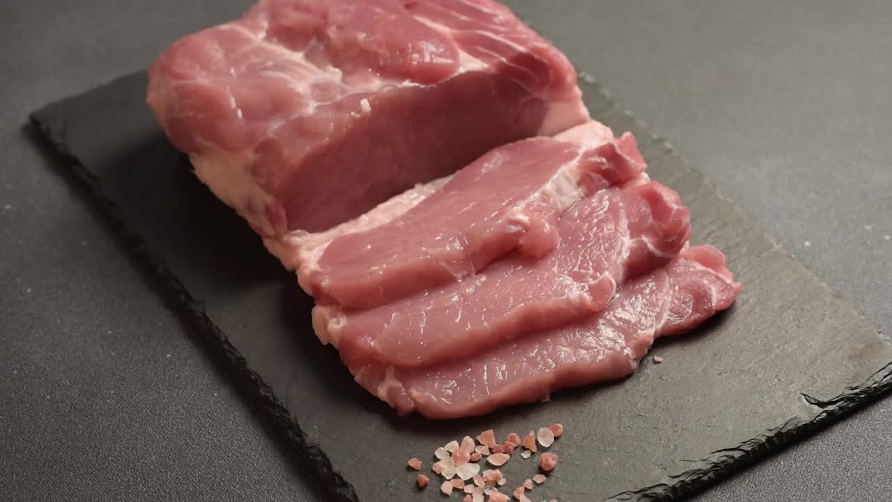 生猪肉排放在砧板上，配上香草和香料视频下载