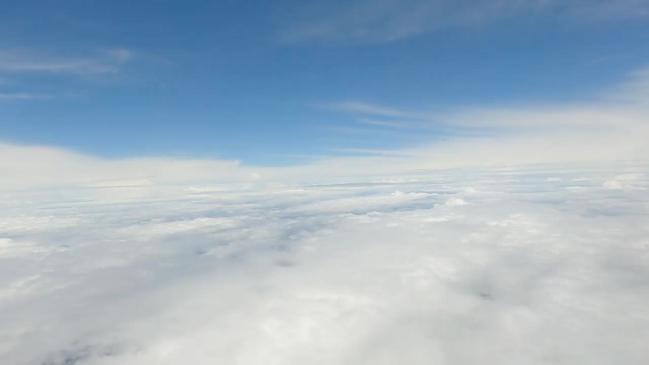 在高高的蓝天上飞着蓬松的云朵。天空空中云景背景的观点。空气中柔和的颜色。神奇的蓝色氛围。阴天的臭氧层。飞机在白天飞行。云彩和天空视频素材