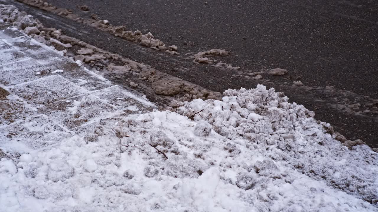 冬天，城市沥青街道上覆盖着冰雪和泥浆视频素材