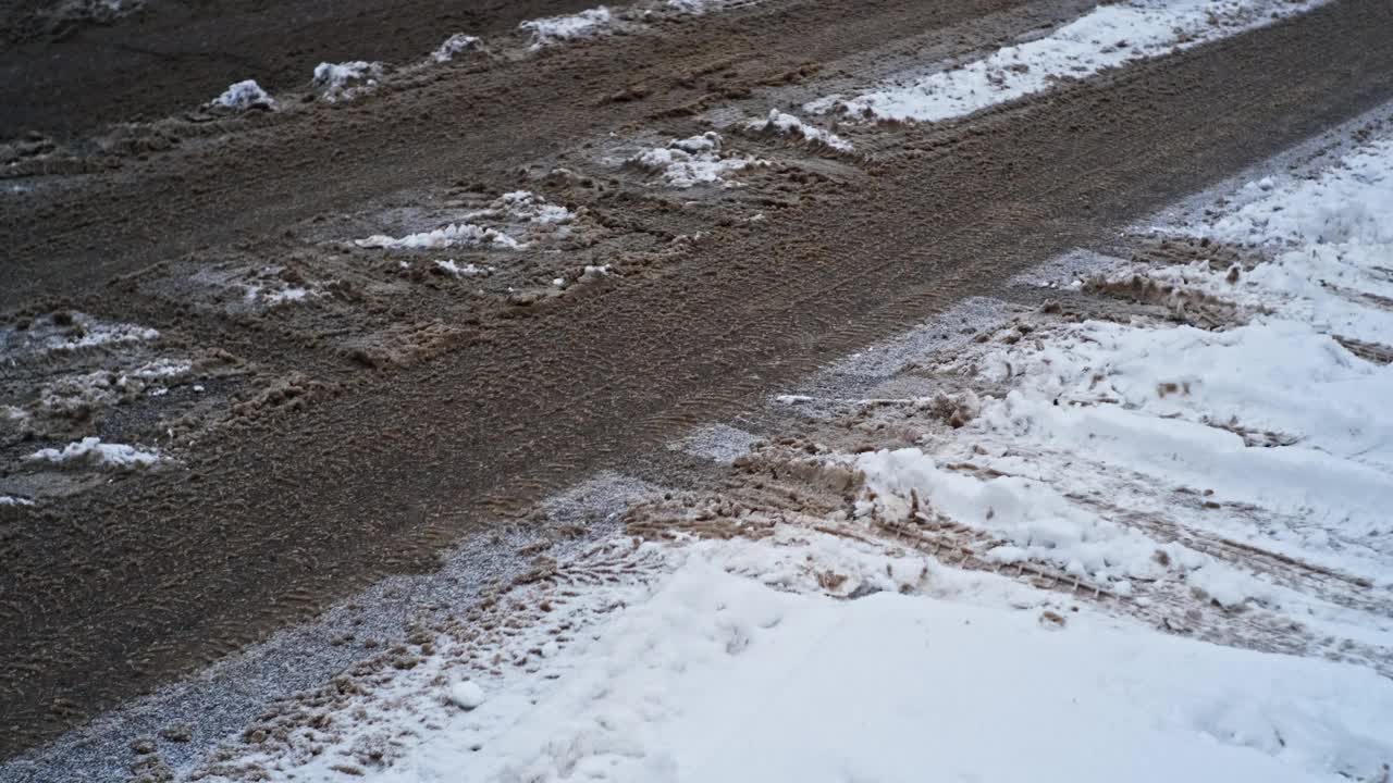 冬天，城市沥青街道上覆盖着冰雪和泥浆视频素材