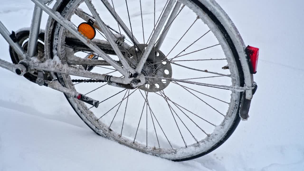 在寒冷的冬天，意外的强降雪暴雪期间，城市自行车覆盖在雪和冻结的雪块视频素材