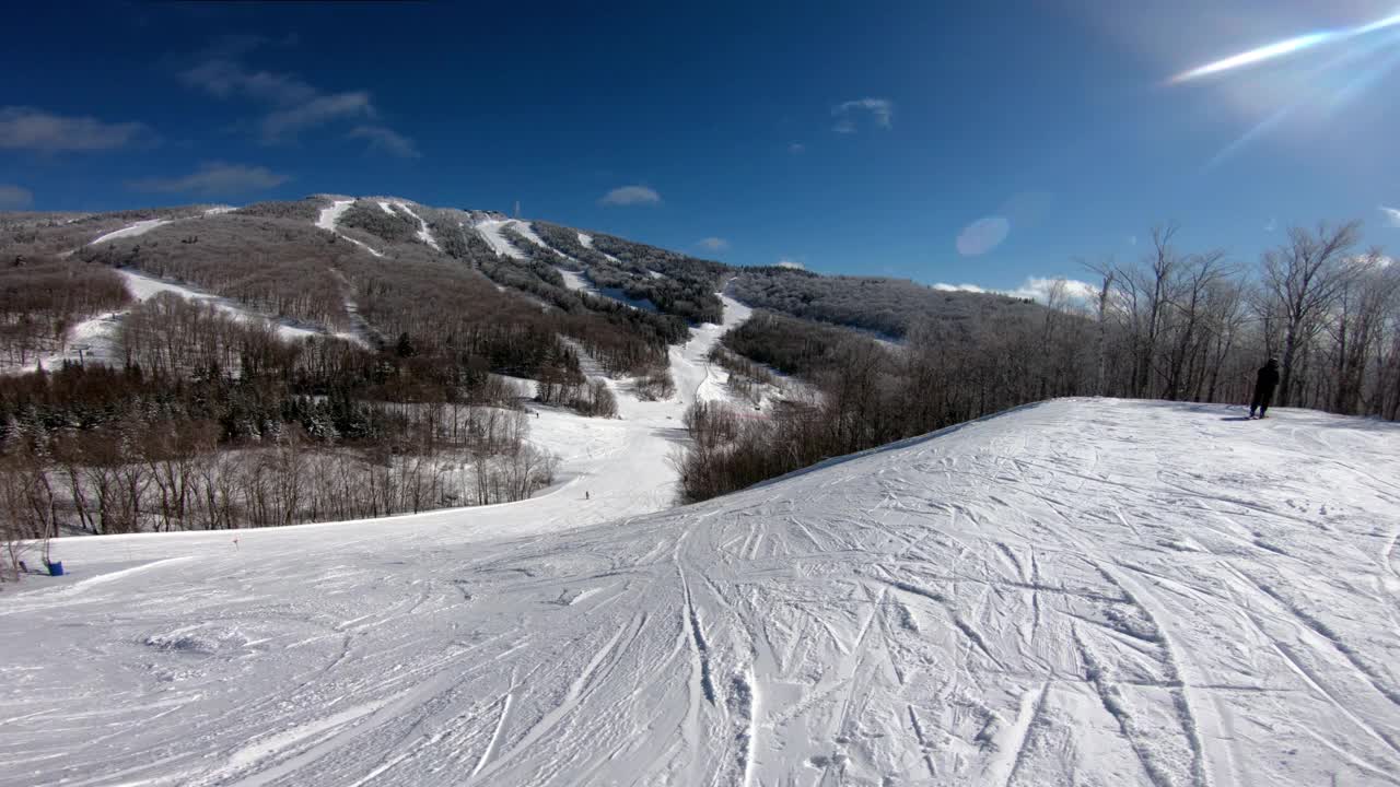 滑雪观点。高山滑雪-滑雪者在冬天下山时对着被雪覆盖的树和滑雪山的背景。蒙特特朗布兰特，魁北克，加拿大。视频素材