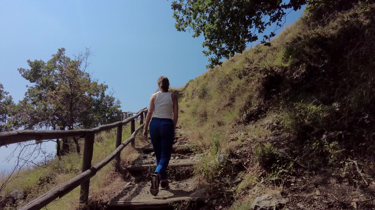 一个女人和孩子走在海边的山上视频素材