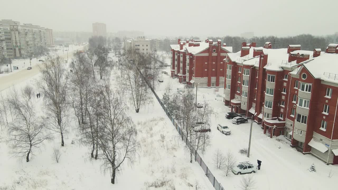 冬天，城市街道上的三层砖房被白雪覆盖。视频素材