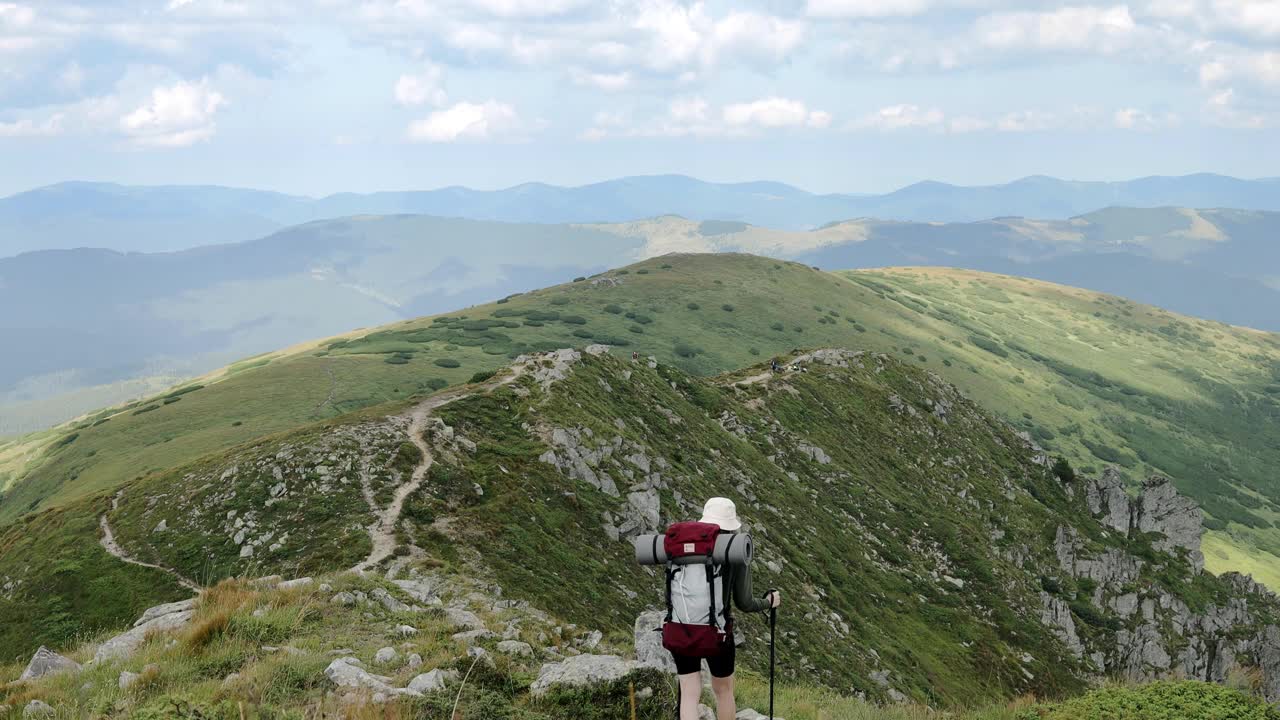 女游客在山顶行走。徒步旅行，享受生活风景自然景观。暑假旅行冒险。背包客徒步登山夏季远足。视频素材