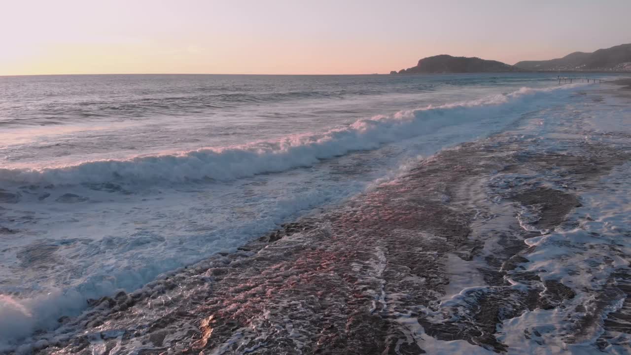 海浪在海上的冲击线，泡沫般的白色质感。汹涌的海浪。巨大而有力的海浪冲击着海滩，碰撞着，溅起水花。神奇的海洋景观。海岸线在日落时分视频素材