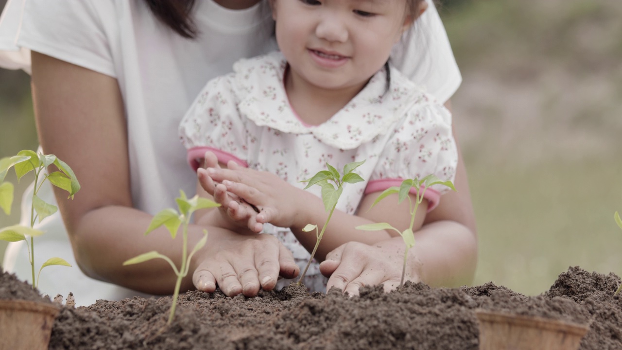 亚洲小女孩和父母抱着和种植幼苗视频素材