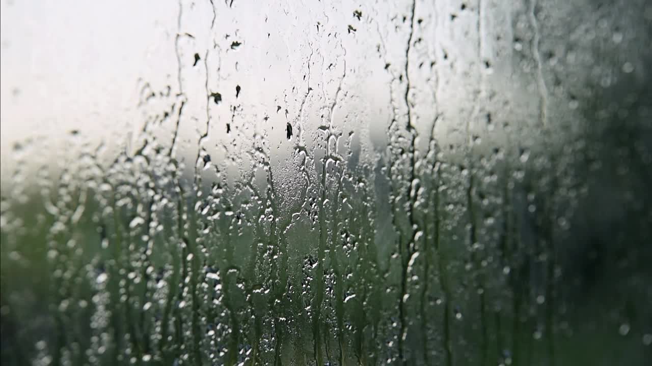 在一个下雨天，雨滴落在玻璃上视频素材