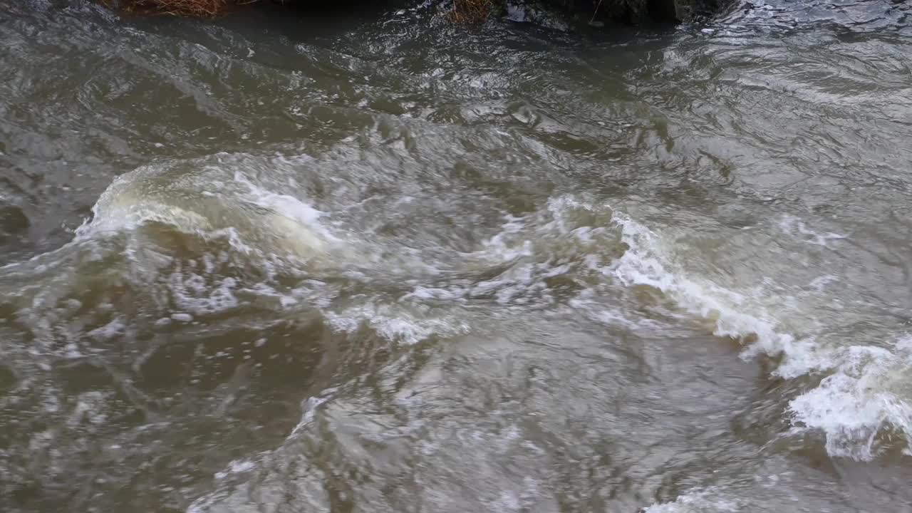 近距离的褐色泥泞的流动的水流在洪水期间视频素材