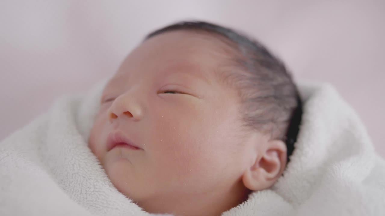 快乐亚洲可爱的儿子新生婴儿睡觉。新出生的。视频素材