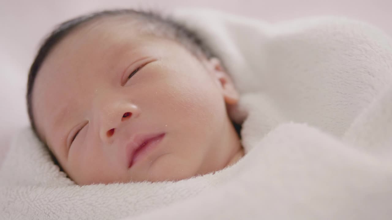 快乐亚洲可爱的儿子新生婴儿睡觉。新出生的。视频素材