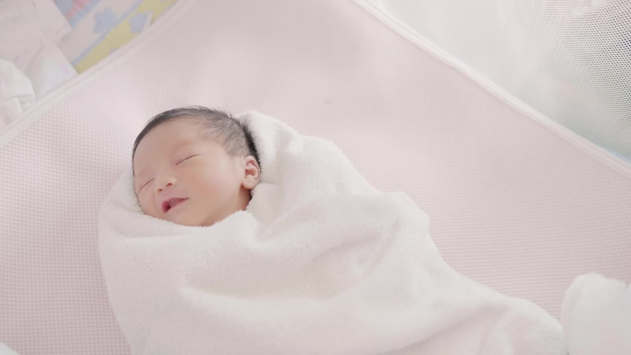 快乐亚洲可爱的儿子新生婴儿睡觉。新出生的。视频素材