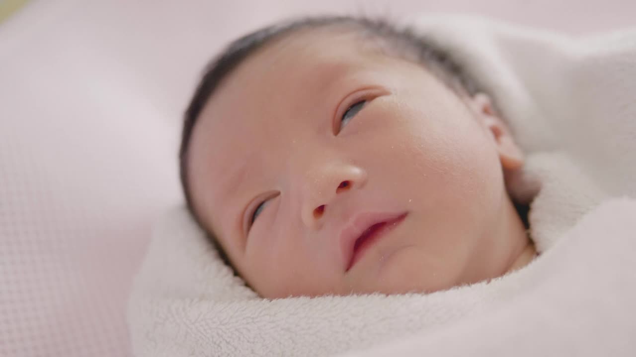 快乐亚洲可爱的儿子新生婴儿睡觉。新出生的。视频素材