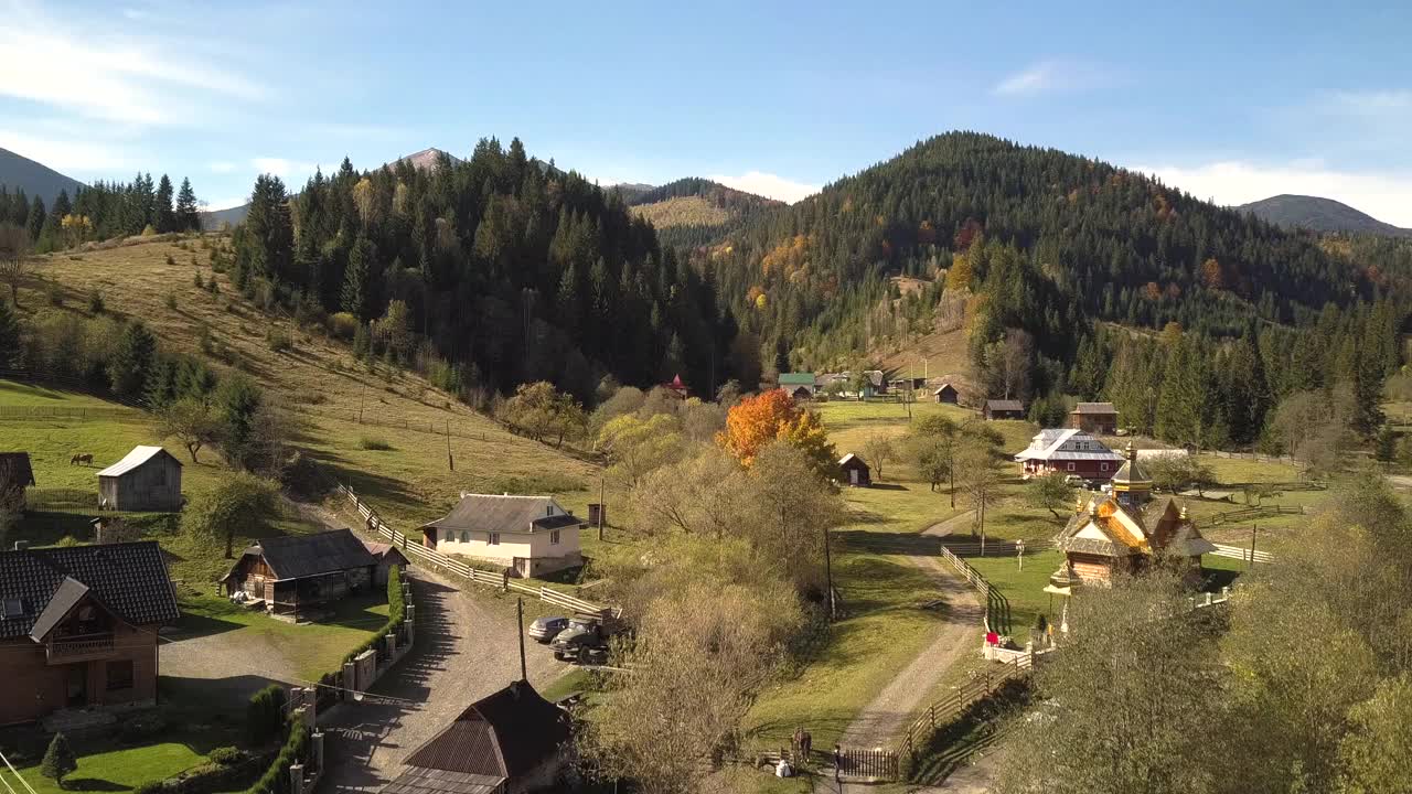 鸟瞰秋山景观，常绿的松树和黄色的秋天森林，远处是壮丽的山脉。视频素材