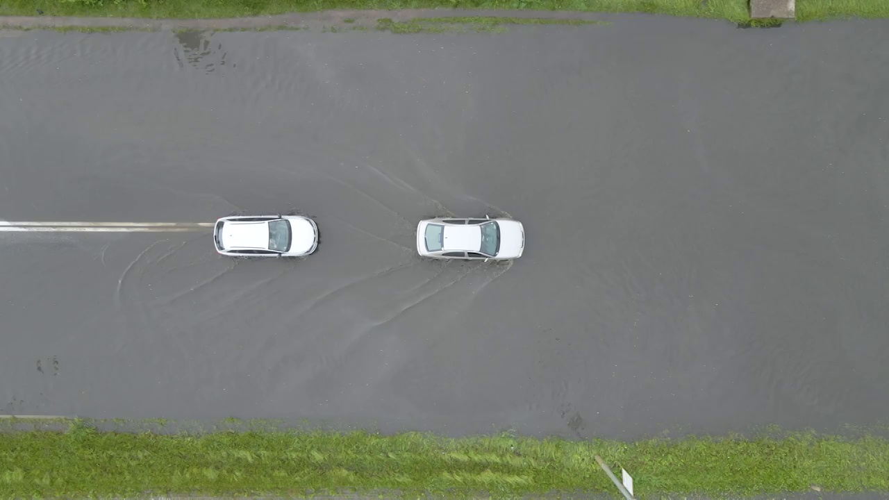 鸟瞰图的城市交通与汽车驾驶在被淹的街道后大雨。道路排水系统的问题视频素材