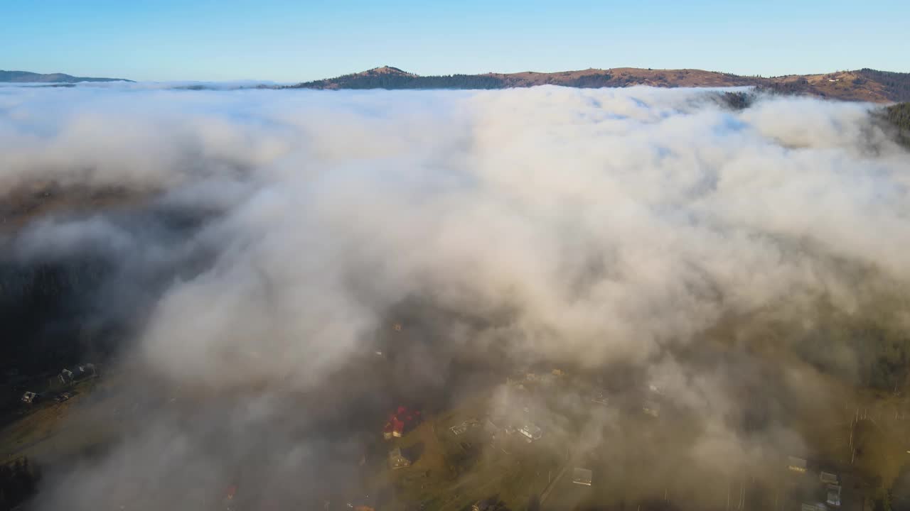 从上面看日出时云雾笼罩着小山和村舍的充满活力的景观视频素材