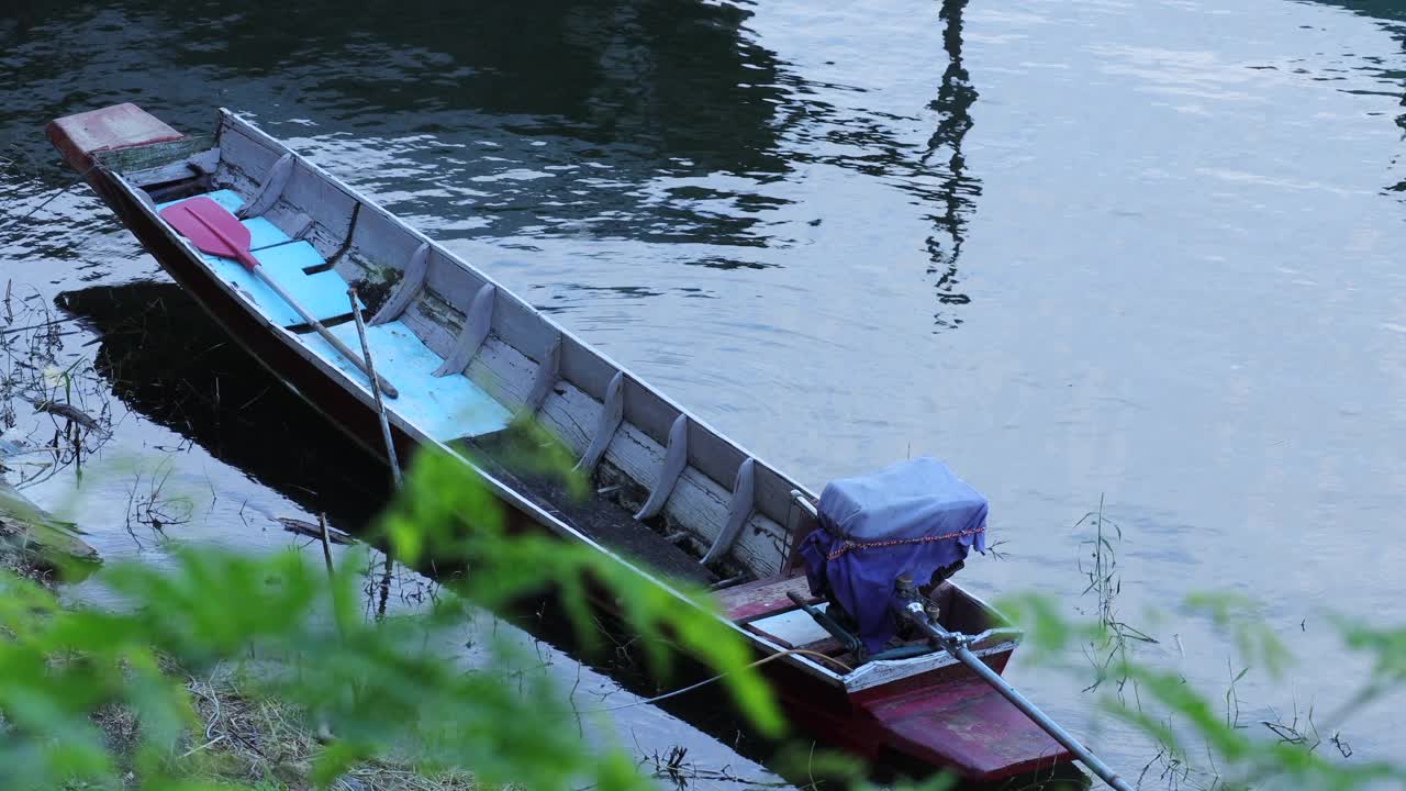 一艘停靠在港口的旧木船的特写镜头。水面上的空小船。视频素材