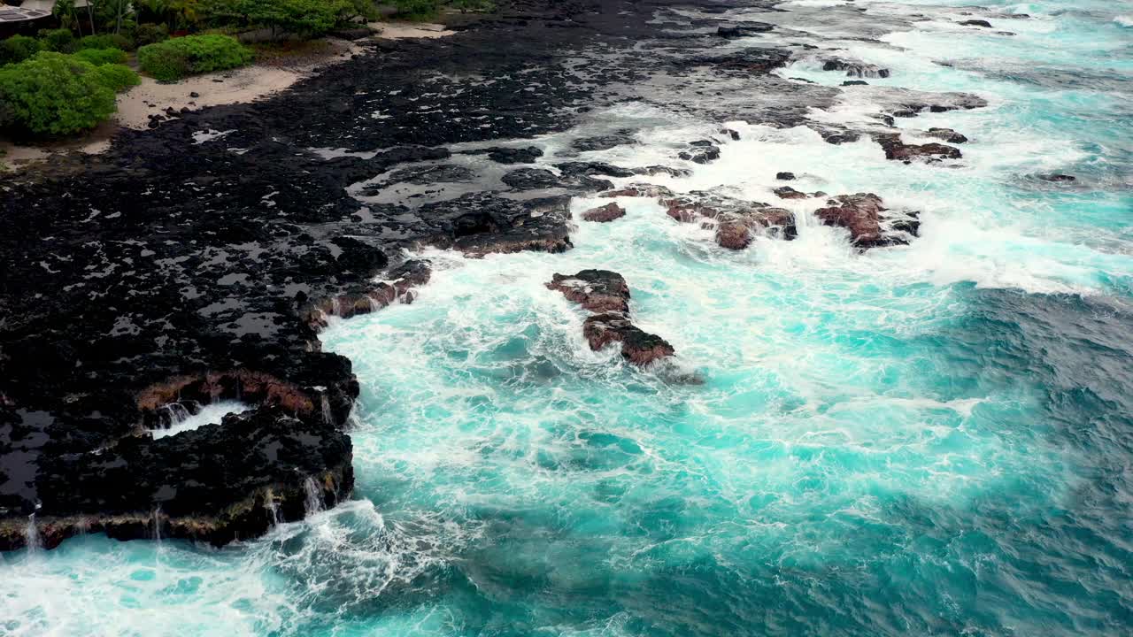 在夏威夷大岛，飞越海浪撞击岩石海岸线视频素材