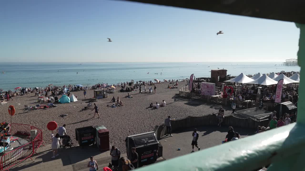 旋转木马和布莱顿皇宫码头和海滨景点与海滩的背景，布莱顿，苏塞克斯，英格兰，英国，欧洲视频素材