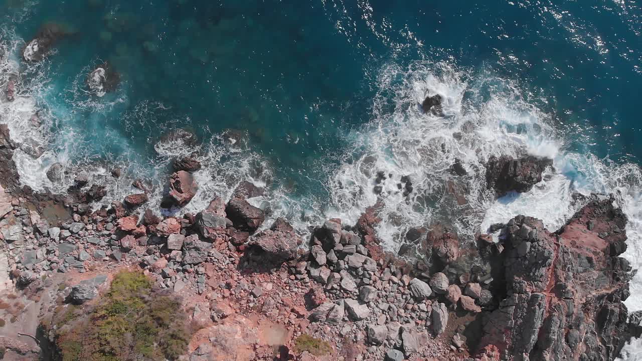 岩石海岸线和海浪。巨大的海浪拍打着海岸的岩石边缘，溅起白色的泡沫。汹涌的海浪和令人惊叹的岩石海岸。美丽的海景视频素材