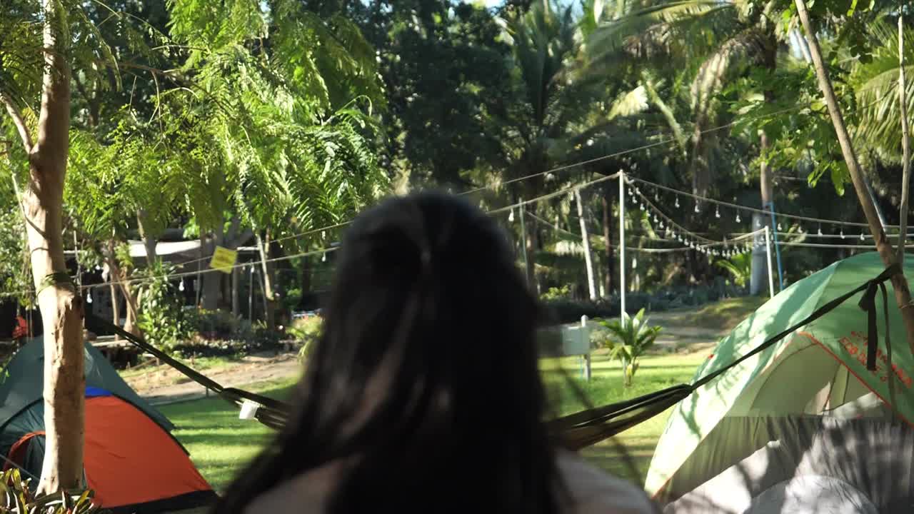 亚洲女孩步行经过帐篷营地与自然背景。视频素材