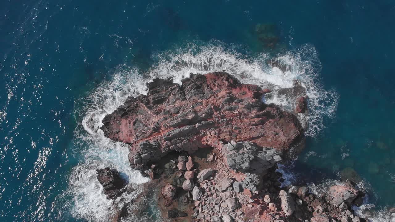 多岩石的海岸景观。有岩石和悬崖的海岸线。海浪击打着岩石海滩，撞击，飞溅，创造出白色的泡沫纹理。自然美。迷人的海滨风景视频素材