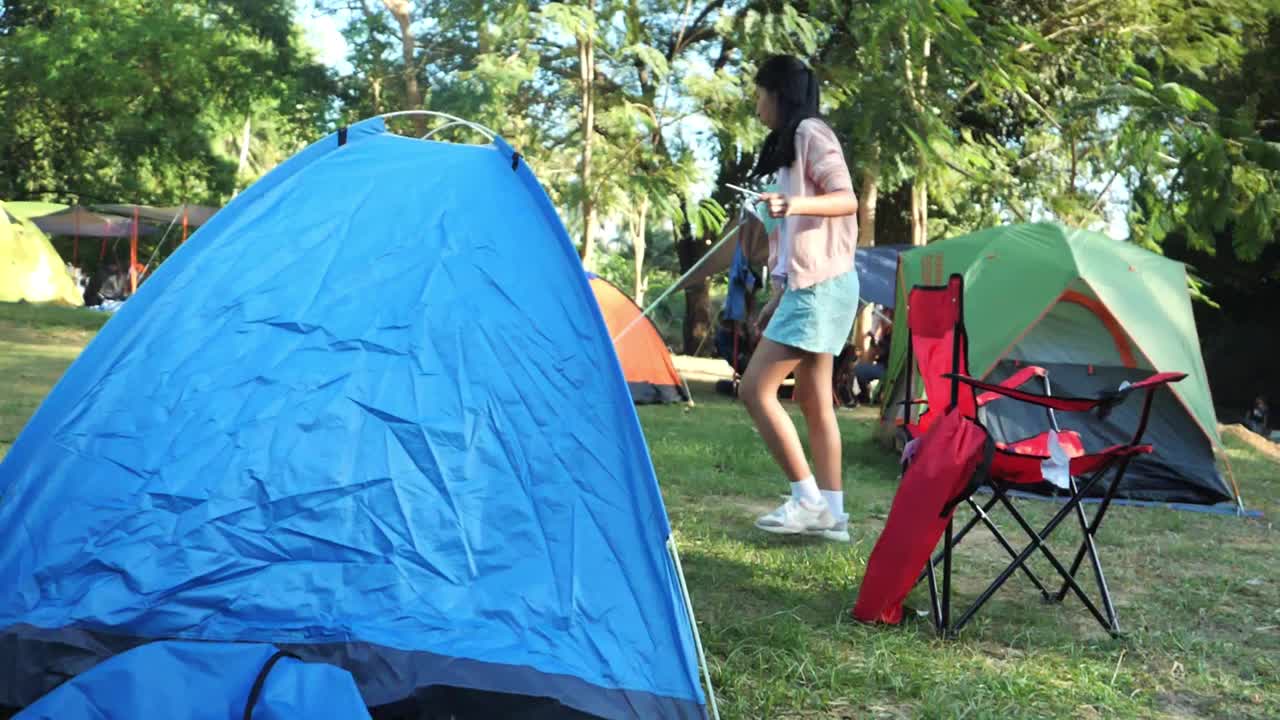 亚洲女孩在露营地露营期间与家人，徒步旅行的生活方式的概念。视频素材