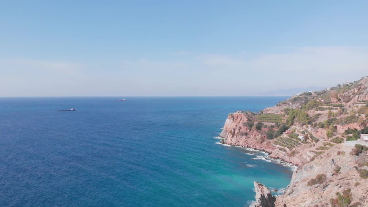 多岩石的悬崖和海岸边缘。海浪拍打着海岸上的岩石。崎岖多石的海滩海岸线。阳光明媚的日子里，岩石嶙峋的海岸线映衬着蓝天。神奇的海景视频素材