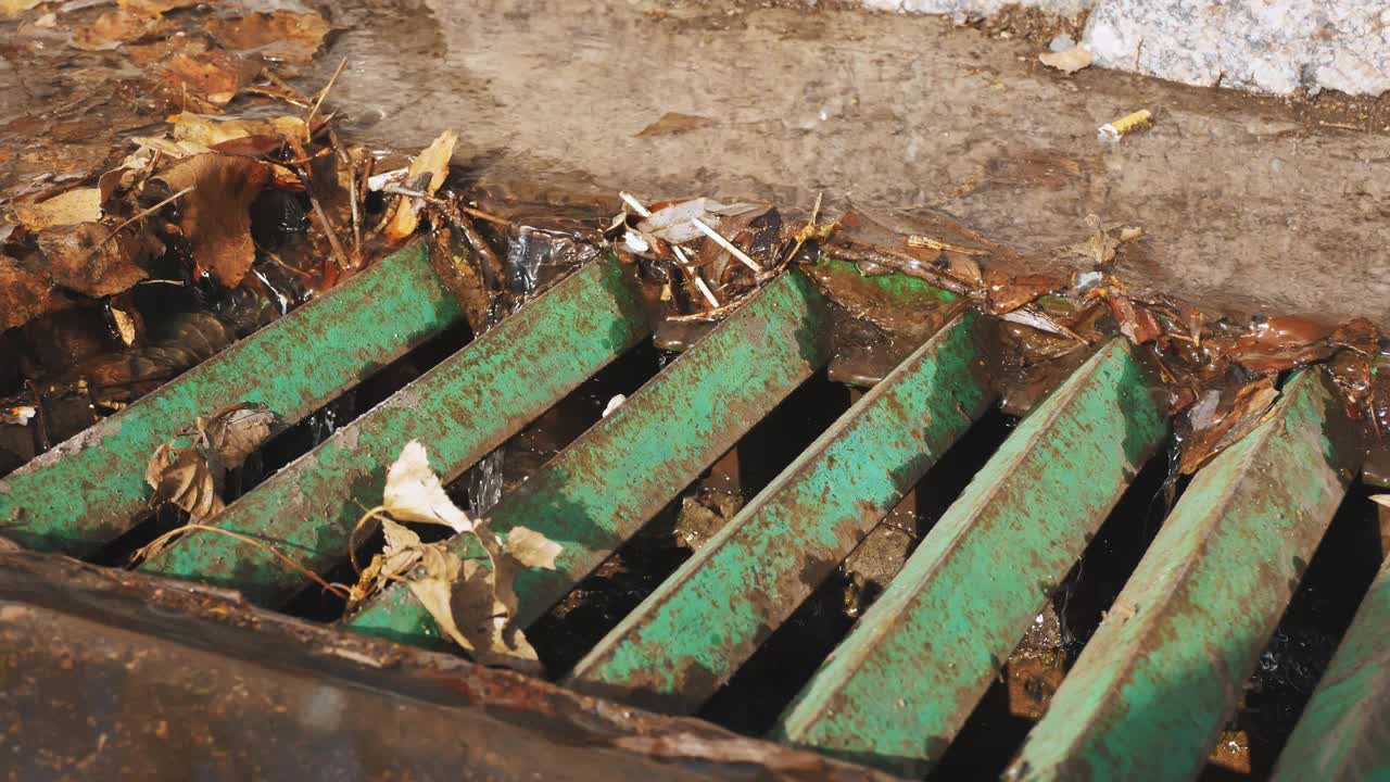 雨水管。城市里春暖花开。融水流入城市污水系统的街道排水沟视频素材