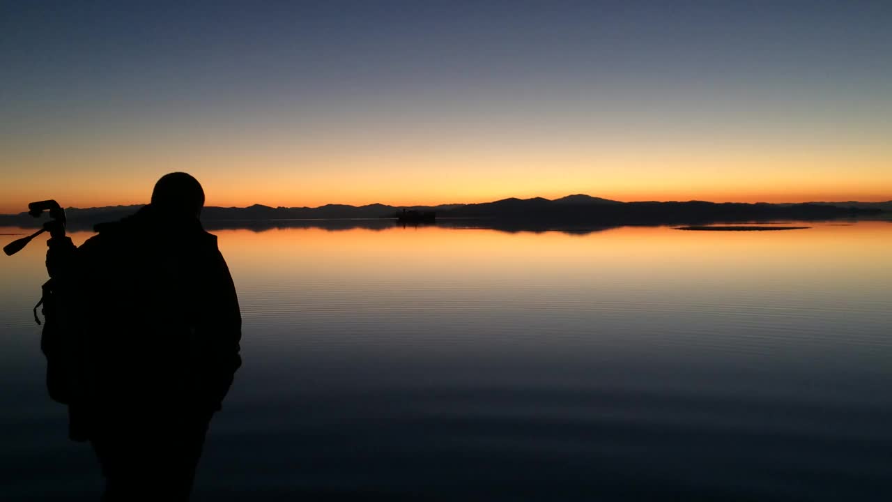 夕阳下漫步在乌鲁木齐湖的浅水上，波浪荡漾视频素材