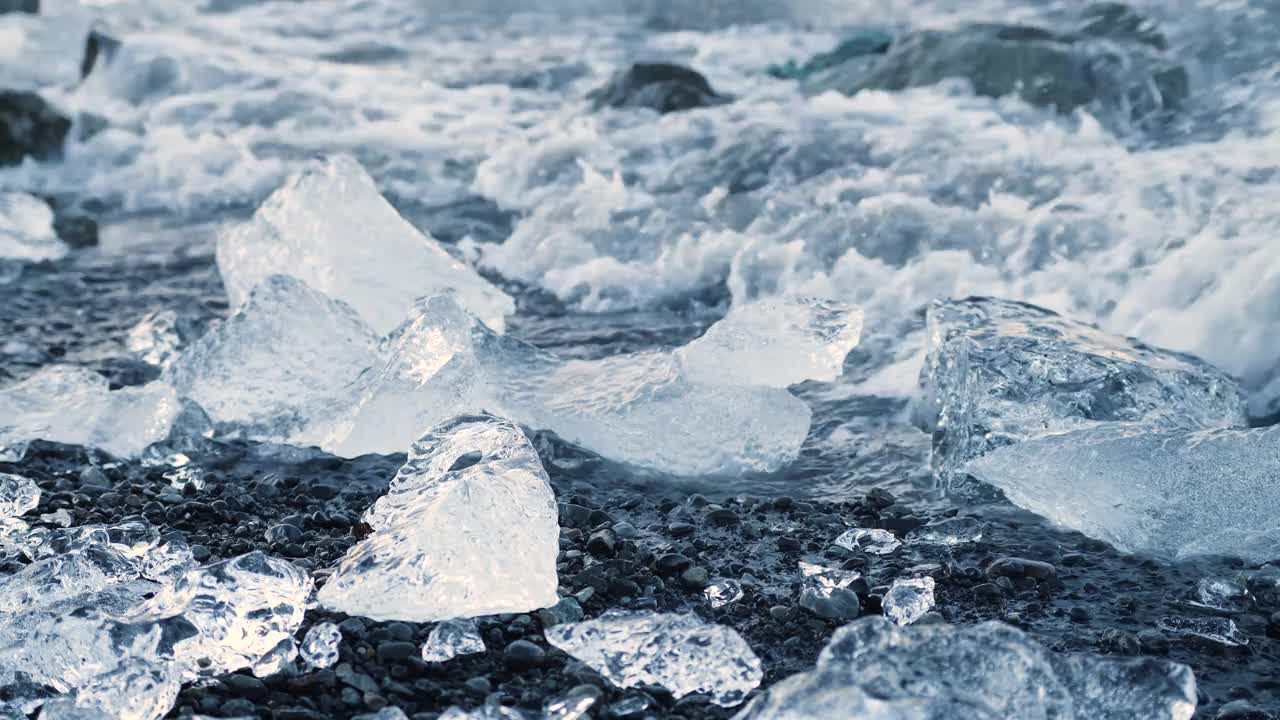 黑沙上的大块冰块，全球变暖气候变化概念，冰岛Jokulsarlon冰川泻湖的冰山视频素材