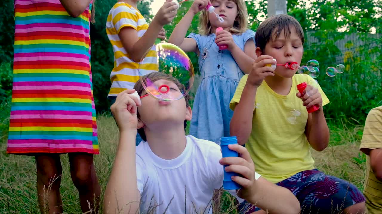 孩子们在街上吹泡泡。有选择性的重点。的孩子。视频素材