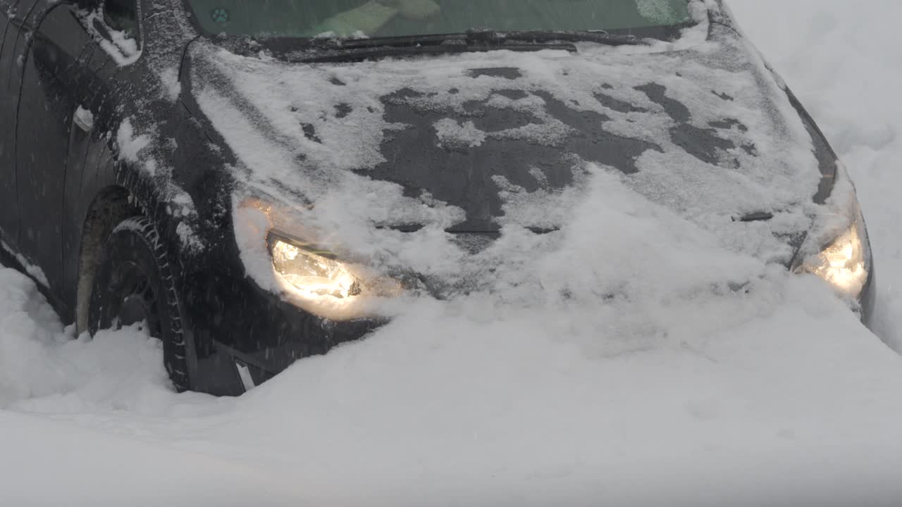 汽车在被雪覆盖的停车场卡在了雪堆里，冬天的暴风雪。视频素材