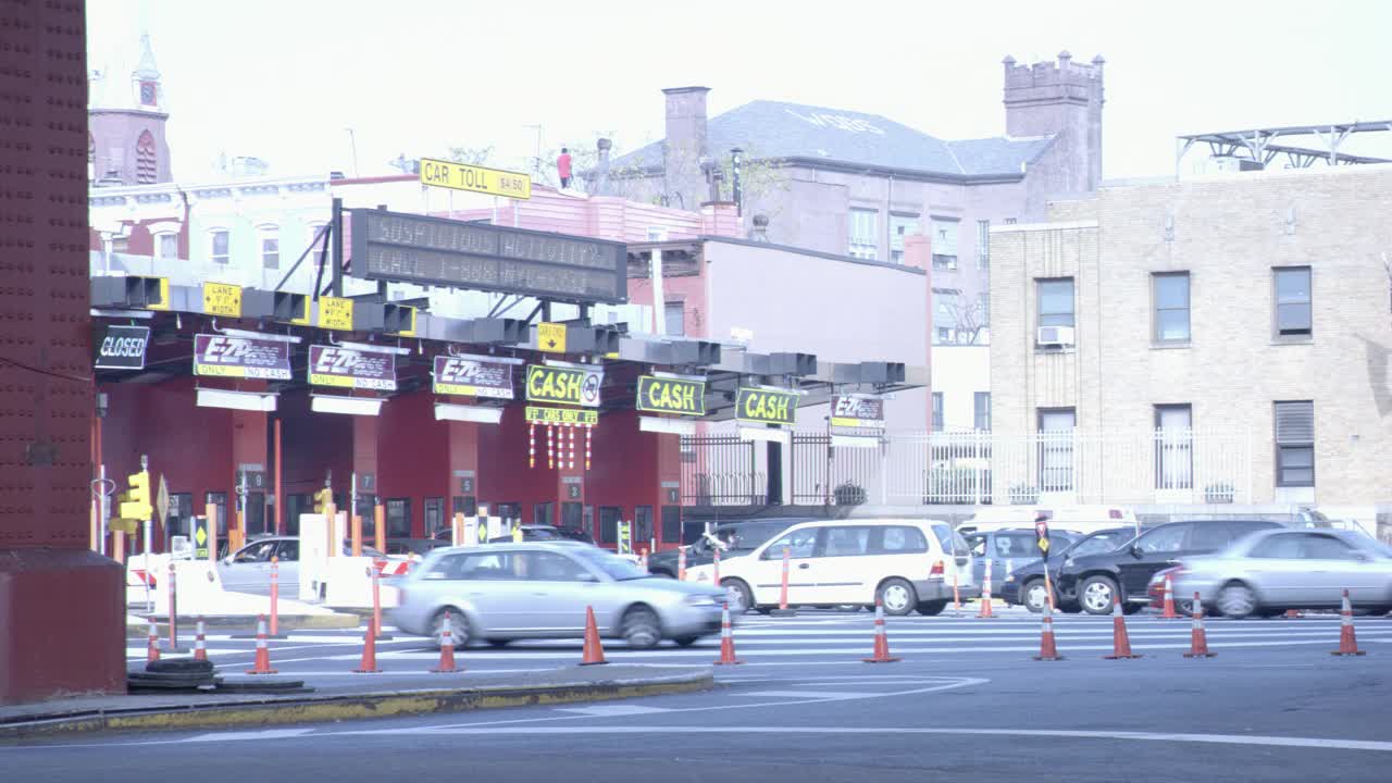 广角汽车通过收费站，收费广场。皇后中城隧道入口，西行。城市的街道。视频素材