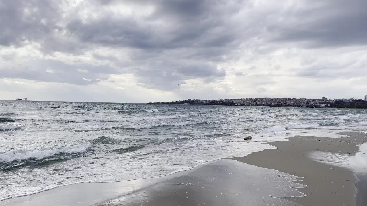 冬季海滩上的海浪和伊斯坦布尔马尔马拉海多云的天气。视频素材